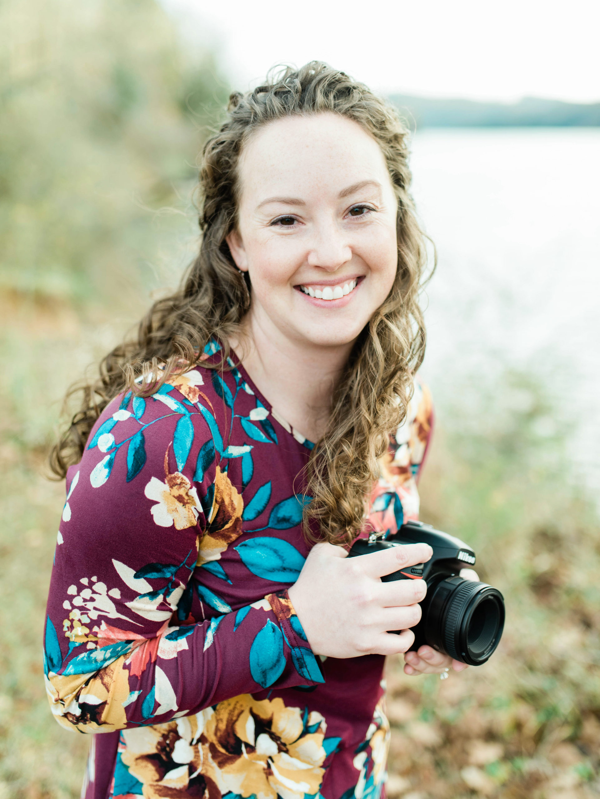 Heather Hamilton, HL Photos owner, a children and family photographer in Knoxville TN smiling with camera