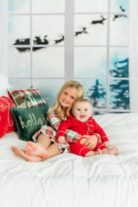 Siblings in matching Christmas pajamas during holiday studio session in Kingston