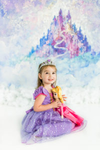 Girl in front of purple princess castle backdrop during Kingston studio session