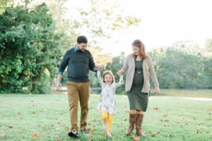 Family of three walking and holding hands at Concord Park in Farragut, TN