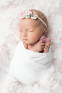 Newborn baby girl holding a pink heart prop, Knoxville newborn photography studio