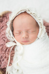 Newborn baby girl wearing a lace bonnet, Knoxville newborn photography studio