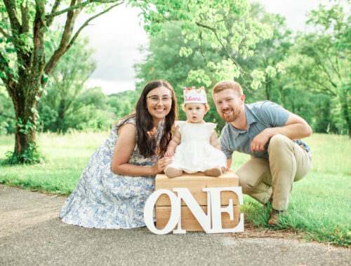 Mom and dad with Juliana sitting on box with ONE letters, Harriman first birthday session