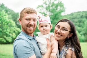 Mom and dad holding one-year-old Juliana wearing birthday crown, Harriman first birthday session