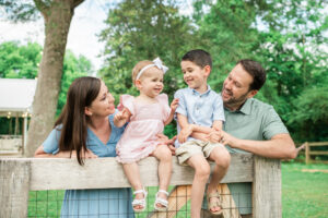 Family of four laughing with kids sitting on fence, Knoxville family photography