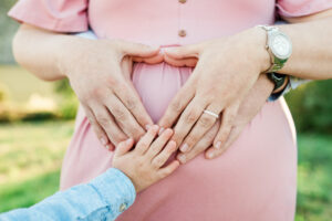 Family's hands together on mom's baby bump, Knoxville maternity session