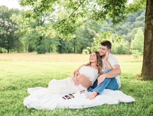 Expecting mom and dad sitting together on a blanket during a maternity session at Lakeshore Park in Harriman, TN