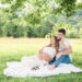 Expecting mom and dad sitting together on a blanket during a maternity session at Lakeshore Park in Harriman, TN