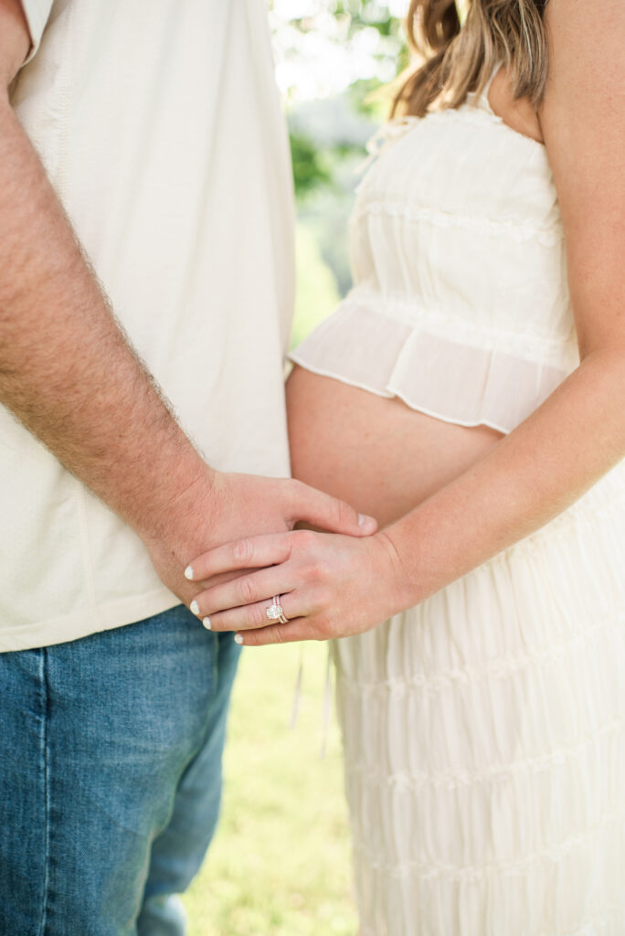 Expecting mom and dad holding hands during a maternity session at Lakeshore Park in Harriman, TN