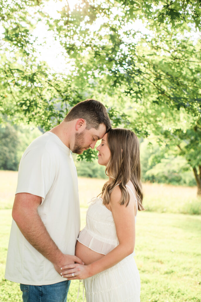 Expecting mom and dad with foreheads together during a maternity session at Lakeshore Park in Harriman, TN