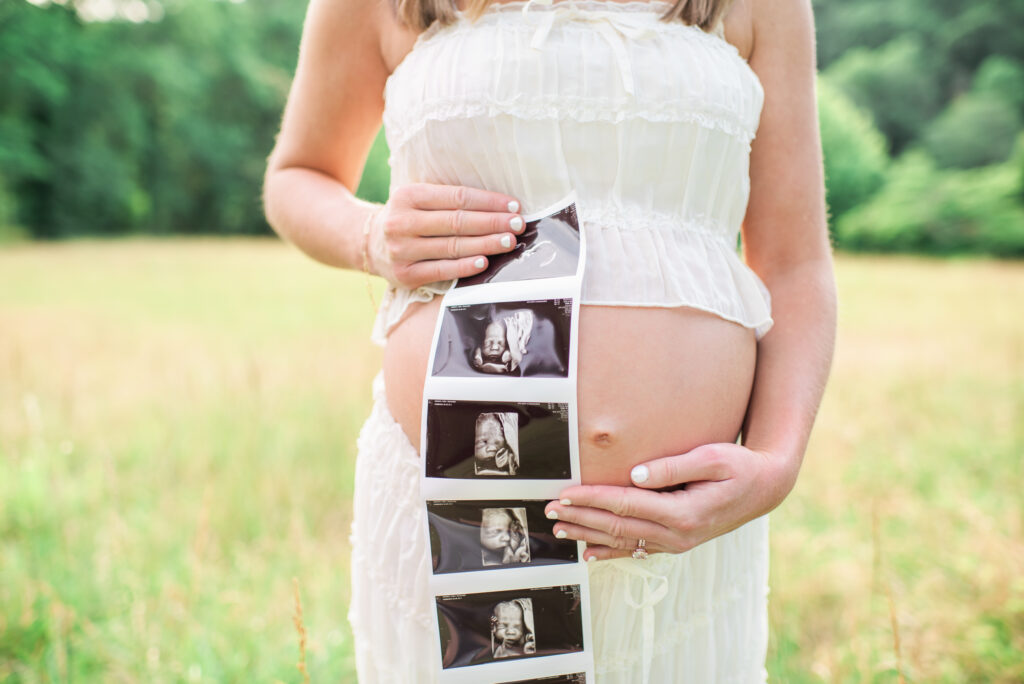 Maternity session detail of ultrasound photo held over the baby bump
