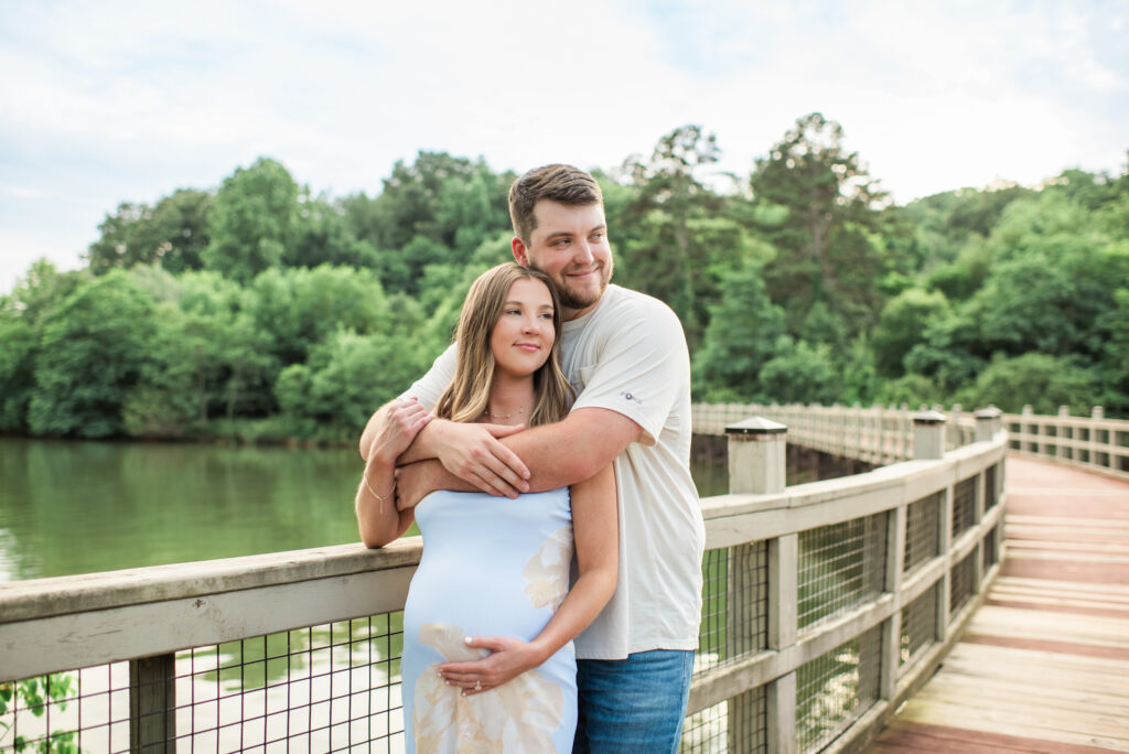 Expecting couple looking out over the water during a maternity session at Lakeshore Park in Harriman, TN