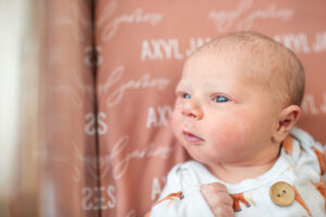 Newborn baby with eyes wide open in hospital bassinet during Fresh 48 session