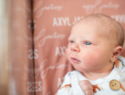 Newborn baby with eyes wide open in hospital bassinet during Fresh 48 session