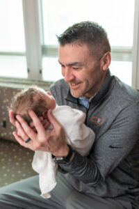Dad holding and looking down at newborn baby during Fresh 48 hospital session