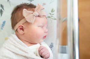 Side profile of sleeping newborn in hospital bassinet during Fresh 48 session