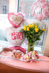 Newborn baby surrounded by balloons and flowers in hospital Fresh 48 photo