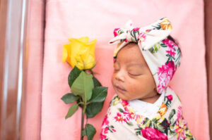 Newborn baby with a yellow flower during Fresh 48 hospital session in Knoxville, TN