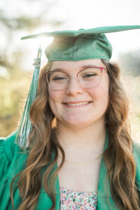 Close-up senior portrait of girl in green graduation cap and gown with 2025 tassel, Knoxville senior photographer