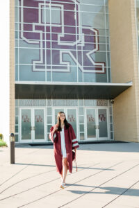 Senior in maroon cap and gown walking toward the Oak Ridge High School entrance
